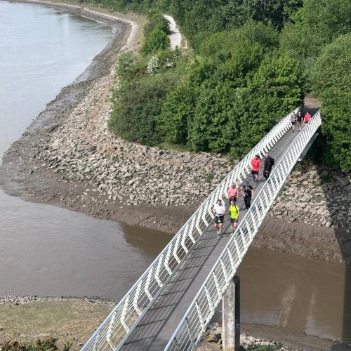 Giant Walkers going over Hale on Mersey bridge
