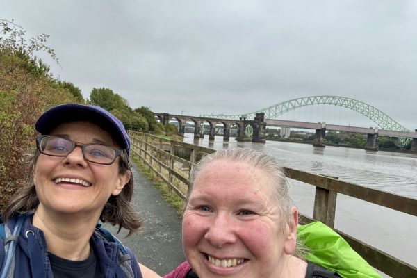 Trekkers walking along the waterside on the Giant Walk for CRY 2025 Hale2Hale.